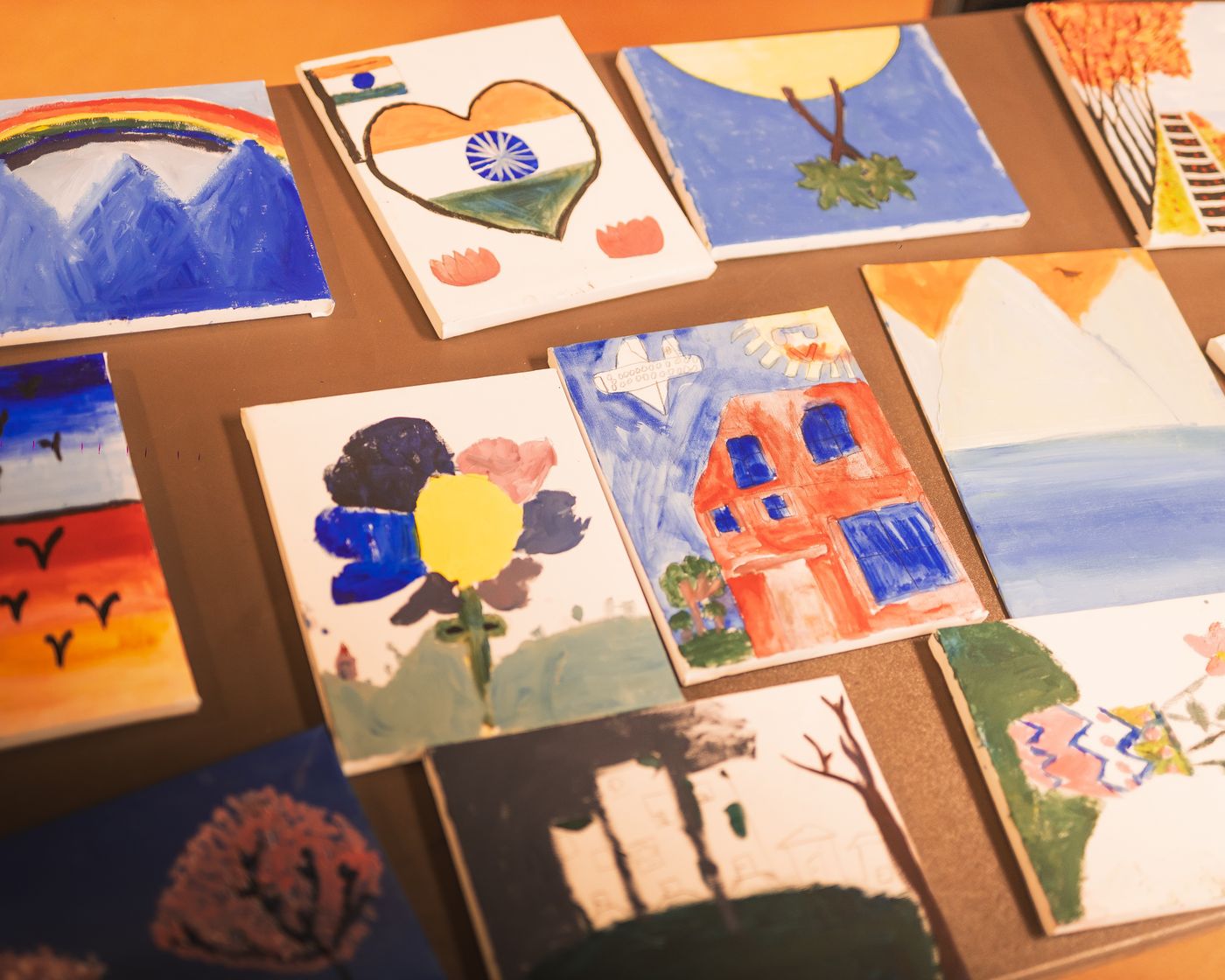 Paintings by students from member schools, displayed side by side.